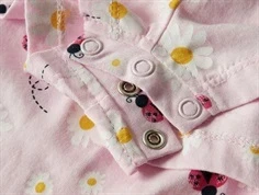 Trykknaplukning på lyserød buksedragt med flyvende mariehøns og blomster 13228171 festival bloom ladybug